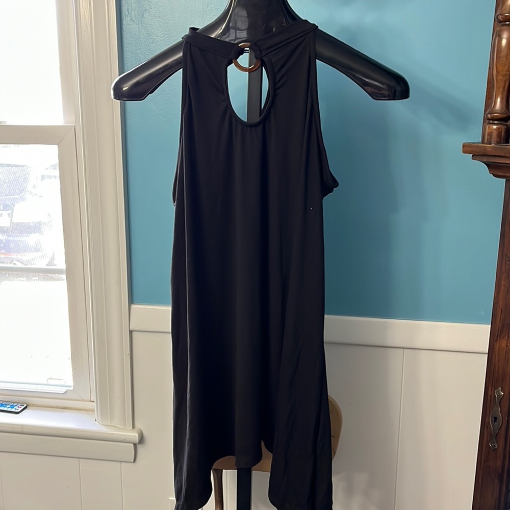 NYC black sleeveless cutout shirt with tortoiseshell ring and button back neck